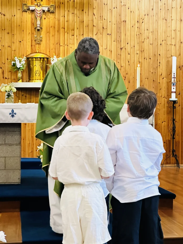Three children receiving the Body of Christ for the first time.